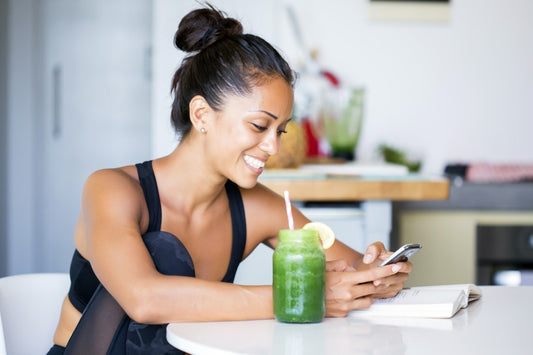 Woman drinking a green smoothie out of a mason jar