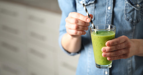  Young woman drinking a green smoothie